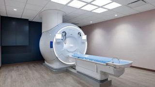 MRI scanner with a circular bore and patient table in a modern radiology room