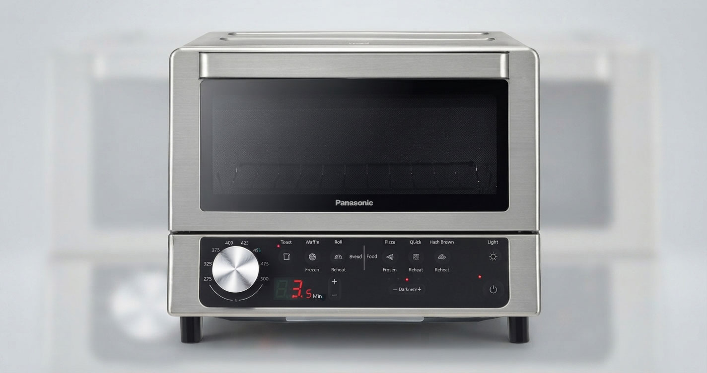 Stainless steel Panasonic countertop oven with a front glass window and a large silver dial on the control panel.