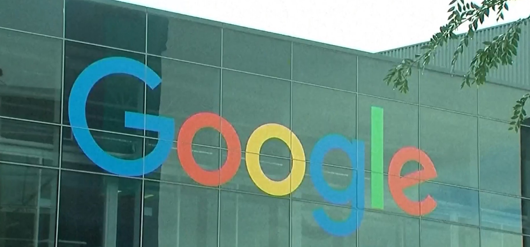 Google logo displayed on a glass building exterior with large colorful letters (blue, red, yellow, green).